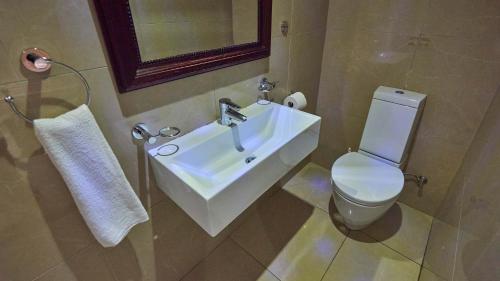 德班2 Sleeper SEA VIEWS Apartment -- Near MSC Cruise Terminal的浴室配有白色水槽和卫生间。