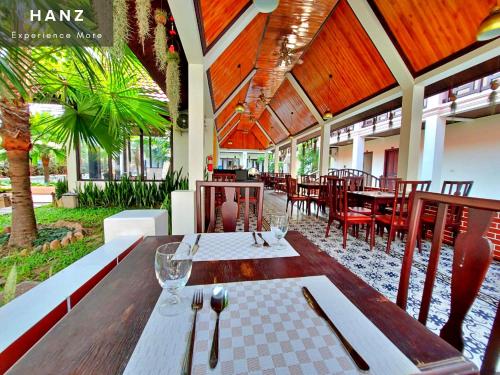 琅勃拉邦Sunrise Hotel Luang Prabang MekongRiver的餐厅内带桌椅的用餐室