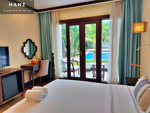 琅勃拉邦Sunrise Hotel Luang Prabang MekongRiver的一间卧室配有一张床、一台电视和一个阳台