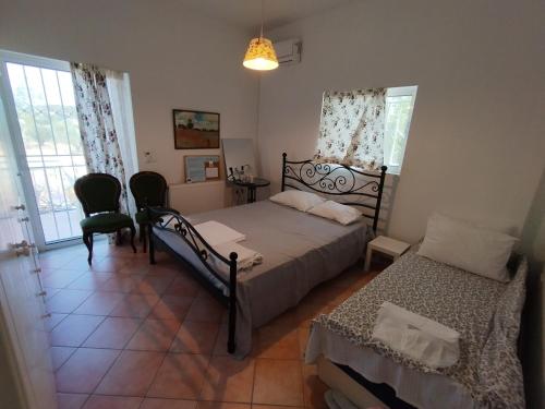 PévkaCostasFarmhouse, Pallini, Near Athens Airport的一间卧室配有一张床、两把椅子和一个窗户