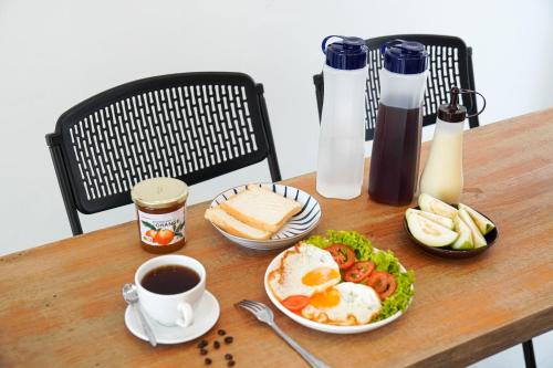 岘港CT HomeStay Da Nang的一张桌子,上面放着一盘鸡蛋,面包和咖啡