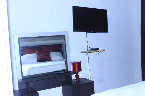 恩潘盖尼Sun & Night的卧室配有一张床,墙上配有电视