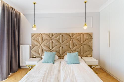 科沃布热格Apartament Westin House 303的一间卧室配有一张大床和两个蓝色枕头