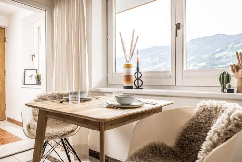 奇勒谷地哈特VIEW4TWO / Chalet-Apartment Zillertal的一间带桌椅和窗户的用餐室