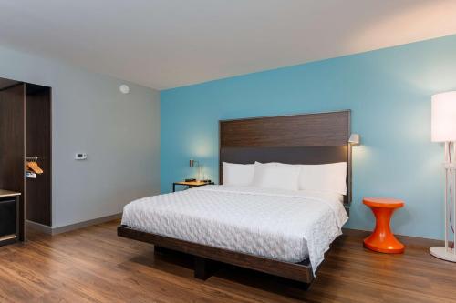 阿什兰Tru By Hilton Ashland, Va的一间卧室设有一张大床和蓝色的墙壁