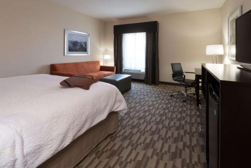 阿尔伯克基阿尔伯克基北/ I-25汉普顿酒店及套房的酒店客房配有一张床、一把椅子和一台电视。