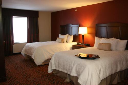 秘鲁秘鲁希尔顿恒庭旅馆&套房酒店的酒店客房设有两张床和一盘食物