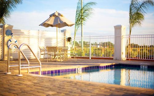 莱克威尔士威尔士湖希尔顿恒庭旅馆&套房酒店的一个带遮阳伞和桌椅的游泳池