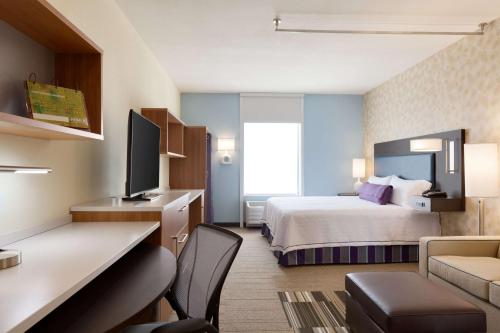 俄克拉何马城俄克拉荷马城奎尔斯普林斯希尔顿欣庭套房酒店的配有一张床和一张书桌的酒店客房