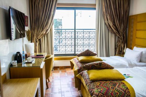 拉巴特Aralia Boutique Hôtel的酒店客房设有两张床和窗户。