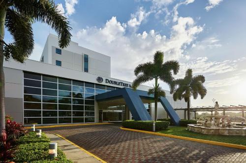马那瓜Hilton DoubleTree by Hilton Managua的一座棕榈树建筑