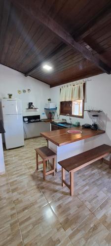 皮帕Porto do Sol - Chalé 07的厨房配有2张长椅、1张桌子和冰箱