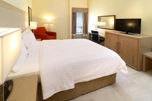 蒙特雷蒙特雷基础汉普顿旅馆的酒店客房设有白色的床和电视。