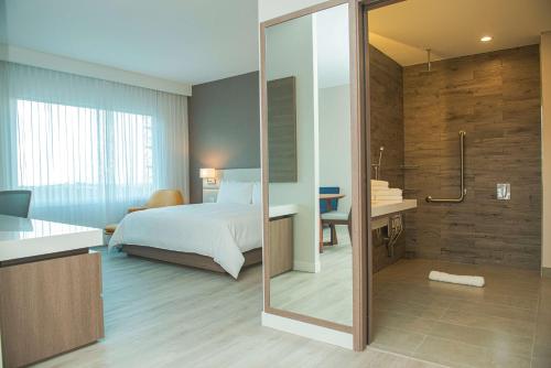 圣何塞Hilton Garden Inn Santa Ana, San Jose的一间卧室配有一张床,浴室设有淋浴。