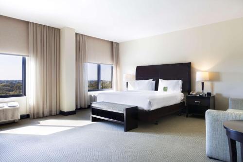 利比里亚Hilton Garden Inn Guanacaste Airport的配有一张床和一把椅子的酒店客房