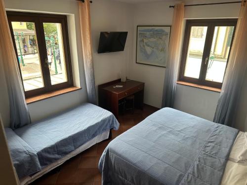 格拉多阿拉齐塔迪特里雅斯特酒店的一间卧室配有两张床、一张桌子和两个窗户。