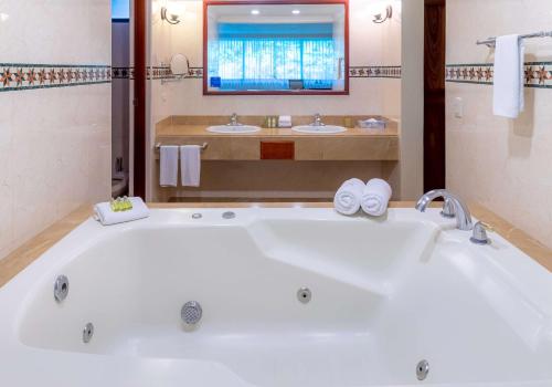 圣何塞Hilton Cariari DoubleTree San Jose - Costa Rica的一个带两个水槽的浴室内的白色大浴缸