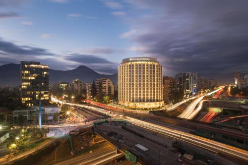 圣地亚哥DoubleTree by Hilton Santiago Kennedy, Chile的夜间有建筑物和高速公路的城市