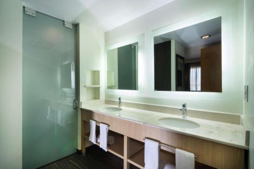 锡劳汉普顿希尔顿思劳阿罗普墨西哥酒店的浴室设有2个水槽和2面镜子