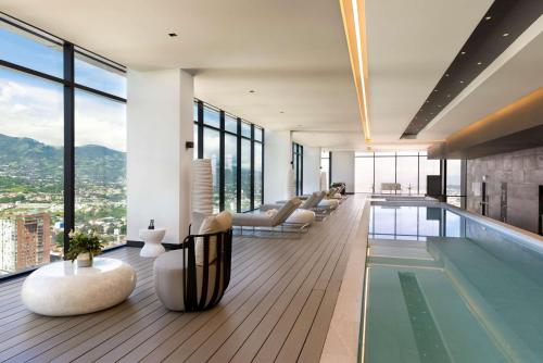 圣何塞Hilton San Jose La Sabana的客厅设有游泳池和窗户