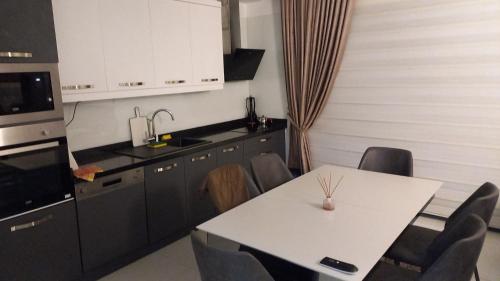 卡吉柯克Eco Marine Residance的厨房配有桌子和白色的桌椅