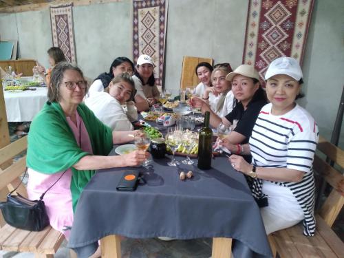 BagdatʼiMaximus Wine Cellar,Bagdati Wine House的一群坐在餐桌旁吃饭的人