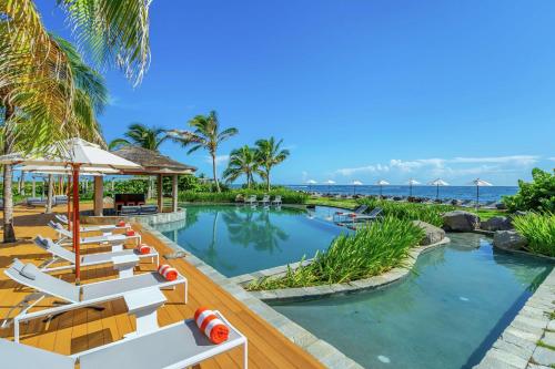 巴斯特尔Koi Resort Saint Kitts, Curio Collection by Hilton的度假酒店的游泳池配有椅子和遮阳伞