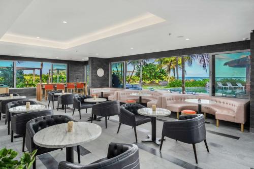 巴斯特尔Koi Resort Saint Kitts, Curio Collection by Hilton的餐厅设有桌椅和大窗户。