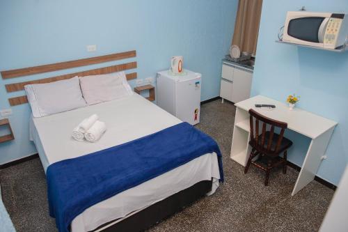 伊瓜苏Click Apê Rodoviária Foz的一间卧室配有一张床、一张书桌和一台电视。