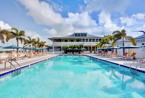 圣佩德罗Mahogany Bay Resort and Beach Club, Curio Collection的一座带椅子的大型游泳池和一座建筑