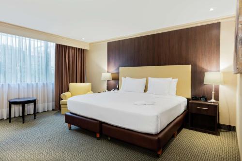 墨西哥城墨西哥城机场希尔顿酒店的酒店客房带一张大床和一把椅子
