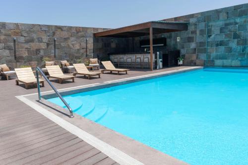 特鲁希略Doubletree By Hilton Trujillo的一个带椅子和壁炉的大型游泳池
