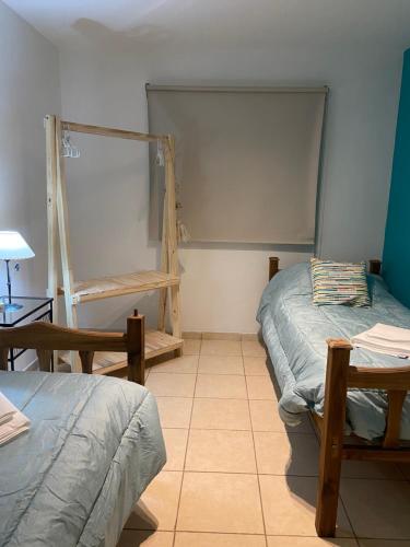 迈普Padre Vázquez Apartment的一间设有两张床、一张桌子和书架的房间