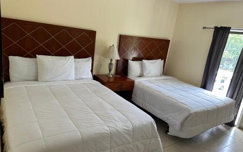 拿骚Sun Fun Hotel的酒店客房设有两张床和窗户。