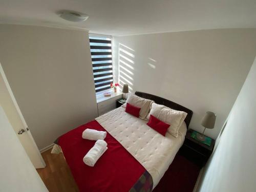 塔尔卡Hermoso Departamento aire acondicionado, Internet的一间卧室配有红色和白色枕头的床