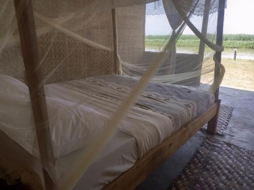 Semliki Fishing River Camp的配有蚊帐的客房内的一张床位