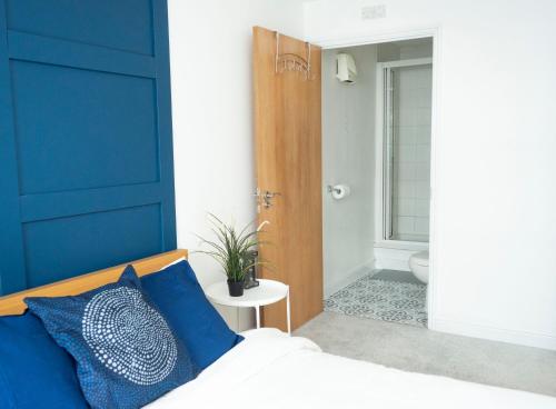 埃普瑟姆Stylish 2 bedroom apartment in the heart of Epsom town centre的一间卧室设有蓝色墙和一张带蓝色枕头的床