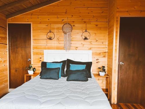 麦德林Monte Santa Elena的一间卧室配有白色床和蓝色枕头
