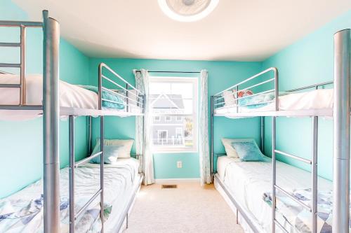 大洋城Seaside Village --- #3的两张双层床,位于带蓝色墙壁和窗户的客房内