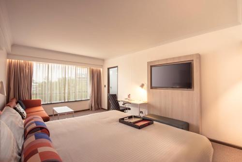 悉尼帕拉马塔莱吉斯酒店的一间酒店客房,配有一张大床和一台平面电视