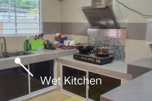 米里Sakura Homestay 4 bedrooms 14pax- Eaton Hills Padang Kerbau Miri的厨房配有水槽和炉灶。