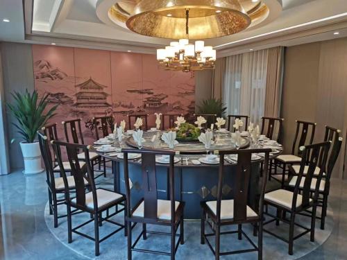 涪陵重庆建峰宾馆的一间带桌椅和吊灯的用餐室