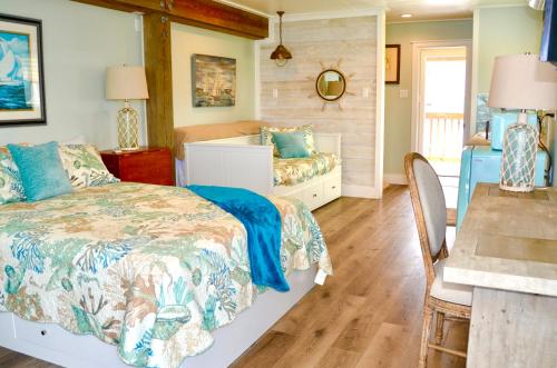 罗克波特Waterfront Guesthouse on Key Allegro/Little Bay with dock的一间卧室配有一张床、一张桌子和一张桌子