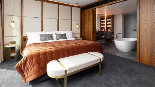 奥克兰Horizon by SkyCity的一间卧室设有一张大床和一个浴缸