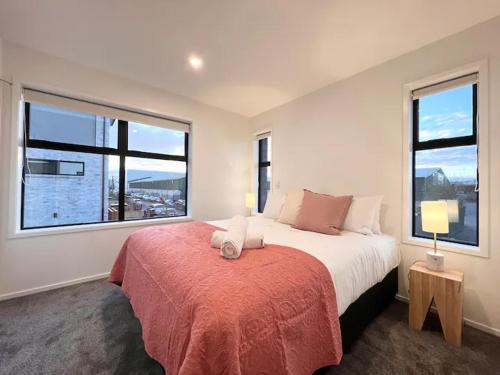 基督城CHCH centre Luxury townhouse close to CBD的一间卧室设有一张大床和两个窗户。