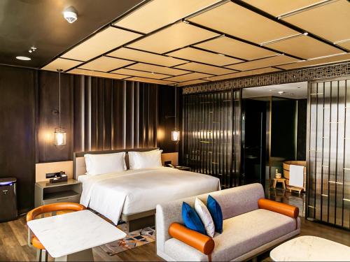 马尼拉Hotel Okura Manila - Staycation Approved的一间卧室配有一张床、一张沙发和一把椅子