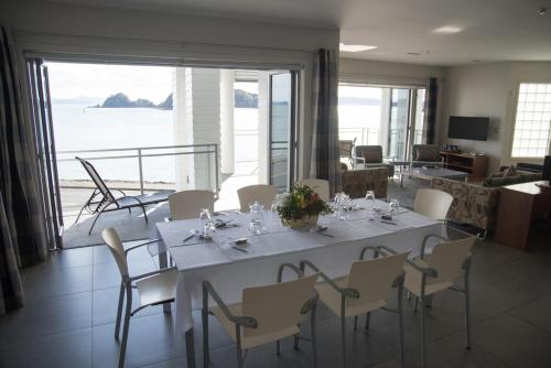 派西亚海滨套房 - 历史公寓式酒店的客厅配有餐桌和椅子,享有海景