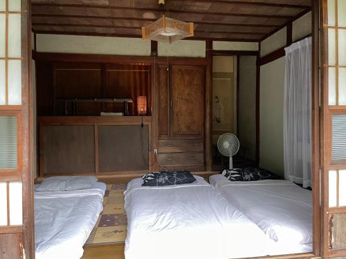 仙台ペット可 Akiu-Canada 鴻ノ巣温泉的客房设有三张床和风扇。