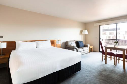 霍巴特老羊毛店公寓酒店的酒店客房设有一张白色大床和一张桌子。