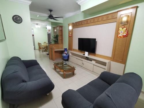 关丹DIY Palm Court 3BR Apartment, 7 Guests的客厅配有2张蓝色沙发和1台平面电视